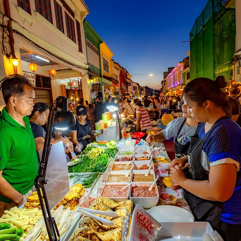 Wieczorny targ z ulicznym jedzeniem wśród kolorowych kamienic Phuket Old Town